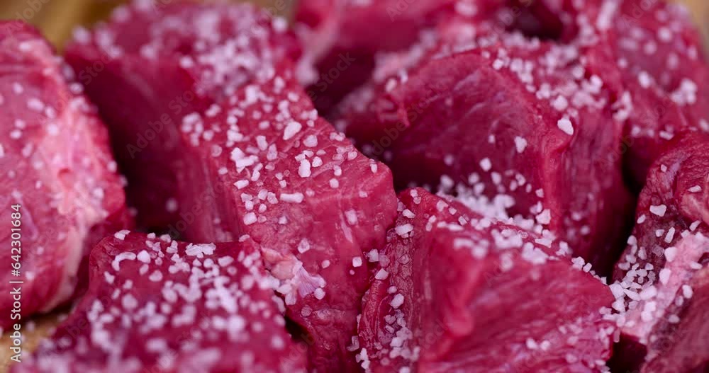 sliced piece of fresh raw beef during salting, preparation of semi-finished products with beef meat with salt