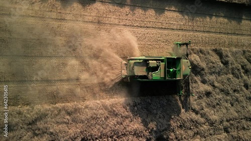 Vertical video. Cobine harvests grain, harvesting finished agricultural products, harvesting, tractor at work, combine harvester in the field. Germany, Melle, 25.08.2023
