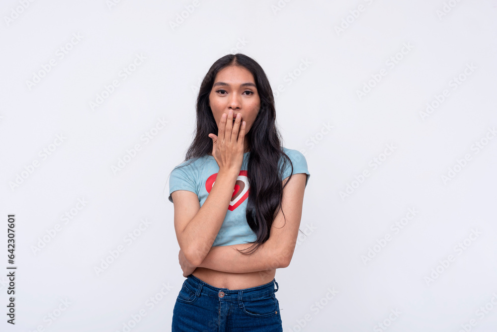 A young asian trans woman exclaiming gosh, covering her mouth in disbelief. Wearing a cute heart printed shirt. Isolated on a white background. A young asian trans woman exclaiming gosh, covering her mouth in disbelief. Wearing a cute heart printed shirt. Isolated on a white background.