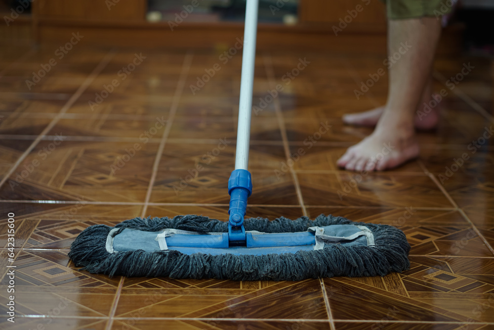 Close up man use a mop to mop the floor. Concept, household chore in