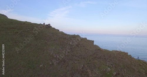 Drone video of a steep bank of the Baikal lake. Drone flies forward from the shore to the lake. There is an evening sky with a bit cloudiness. photo