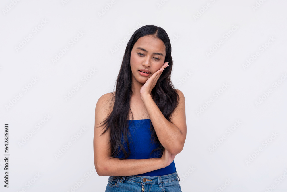 A young Filipino woman feels like a total bummer after a bad toothache. Putting her hand on her jaw. Isolated on a white background. A young Filipino woman feels like a total bummer after a bad toothache. Putting her hand on her jaw. Isolated on a white background.
