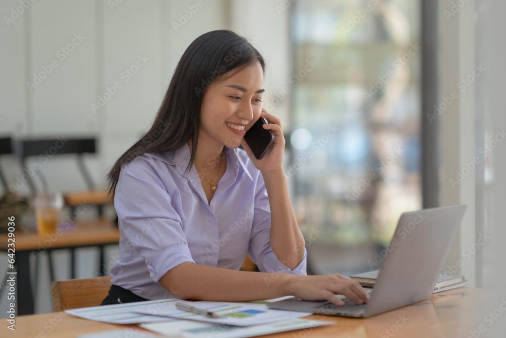 Asian businesswoman modern professional talking with client on the phone with a confident demeanor and effective communication skill. business, marketing, sale and communication project. Asian businesswoman modern professional talking with client on the phone with a confident demeanor and effective communication skill. business, marketing, sale and communication project.