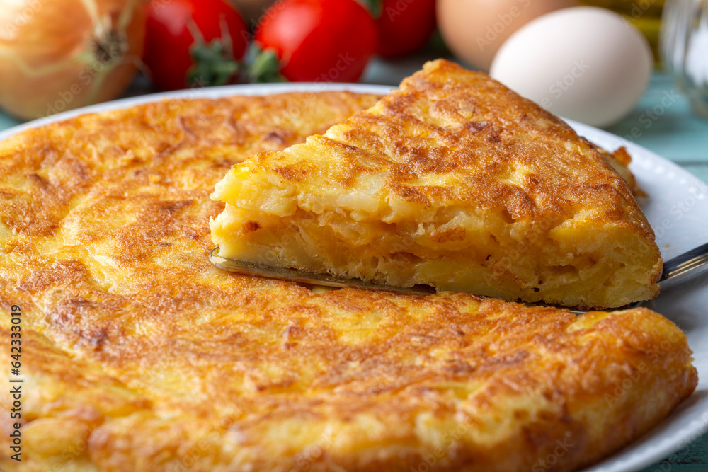 Spanish omelette with potatoes, typical spanish cuisine on gray concrete floor. Tortilla
