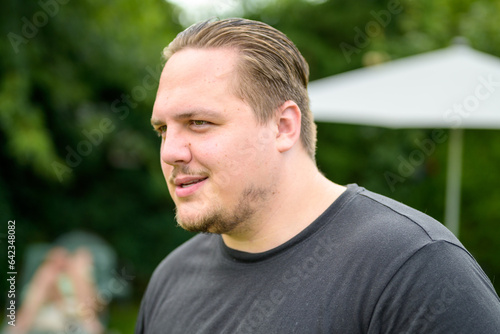 Young man in his twenties looks sideways in a friendly manner