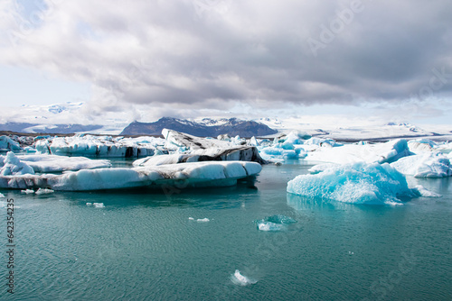 Ice floes in a glacial lake in Iceland with vulcano mountains in the background, the climate crisis in northern Europe, glacial melting, beautiful landsacpe