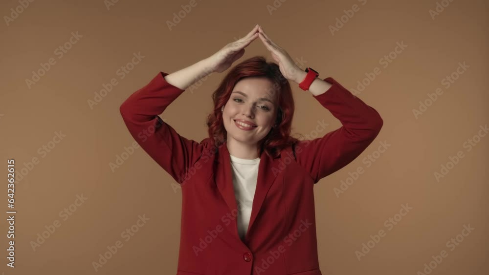 Medium isolated video of a dissatisfied, anxious and sad young woman holding hands over her head imitating a roof and looking from underneath it. Medium isolated video of a dissatisfied, anxious and sad young woman holding hands over her head imitating a roof and looking from underneath it.
