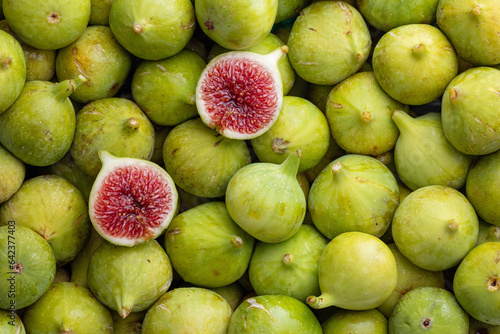 Pile of fresh, honey sweet, green figs, one cut open.