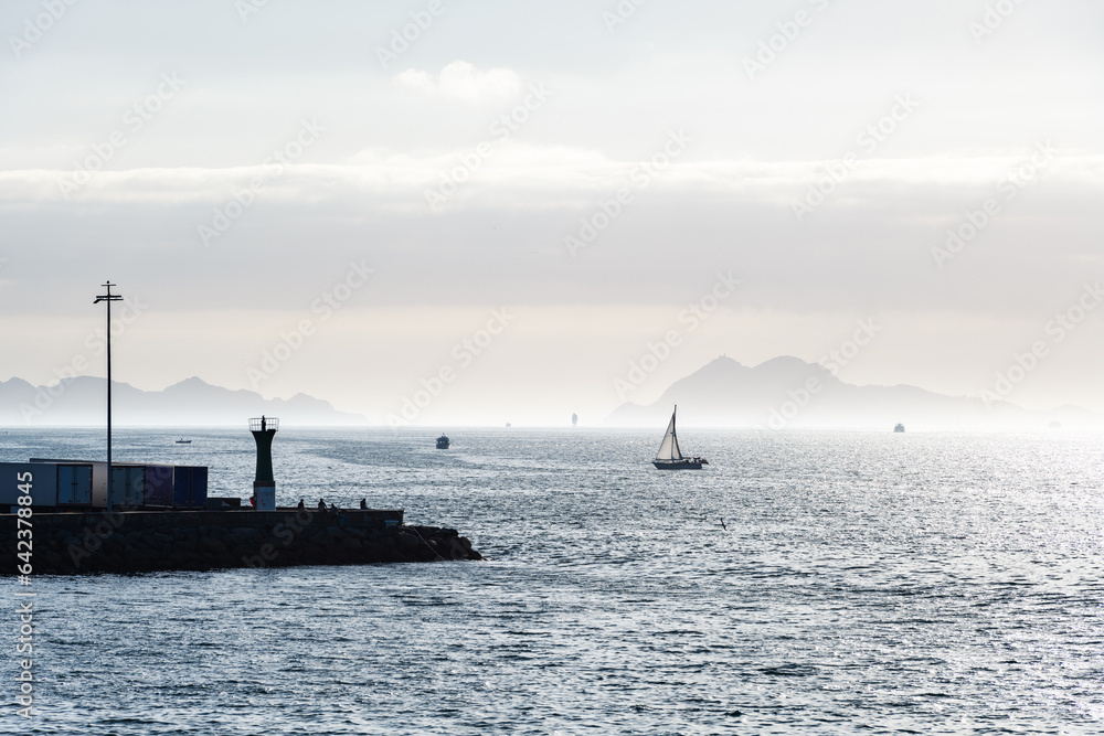 Boats sailing in the Ria de Vigo in Galicia at dusk, with the Cies Islands in the background.