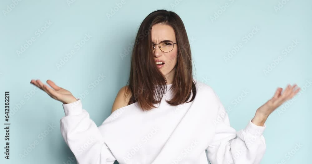 Brunette indignant woman showing bla bla bla gesture with hands isolated on studio blue background. Empty promises, blah concept. Lier. Brunette indignant woman showing bla bla bla gesture with hands isolated on studio blue background. Empty promises, blah concept. Lier.
