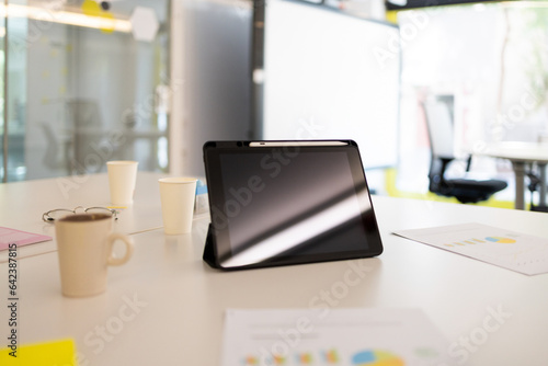 Tablet with cup of coffee on table photo