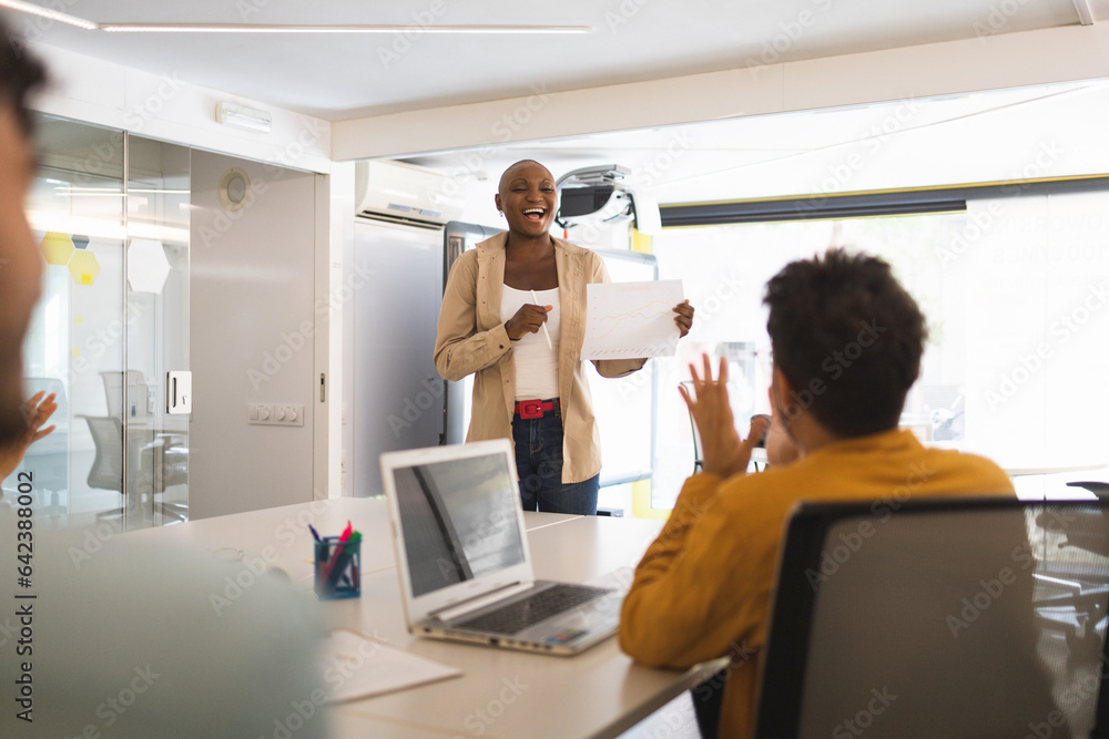 Colleagues clapping to black woman with paper Colleagues clapping to black woman with paper