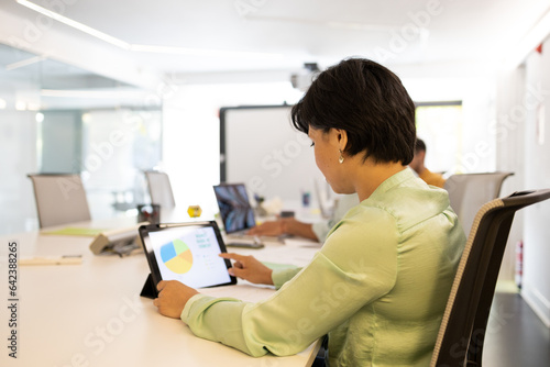 Wallpaper Mural Focused woman working on tablet at office table in lights Torontodigital.ca