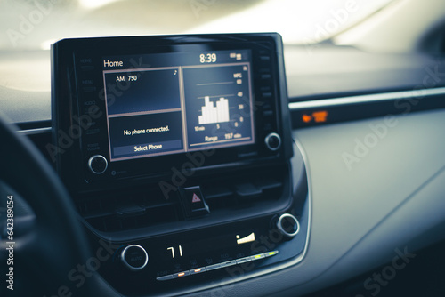 Modern LCD display with milage range fuel economy charts, high temperature setting knobs, inside new car, defrost mode fan at full blast for defogger windshield windows © trongnguyen