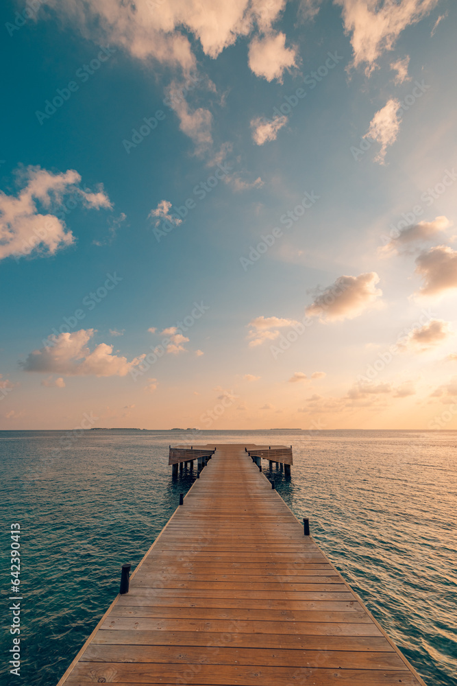 Beautiful seascape long jetty pier at sunset. Minimal sea sky, calm water surface and reflections. Colorful peaceful sunrise tones orange, gold, blue. Tranquil relaxing panoramic inspire meditation