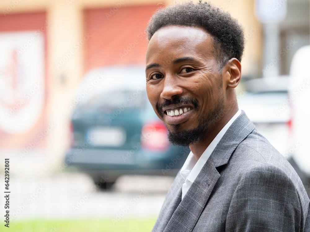 Cheerful young black businessman sitting in formal suit in daylight Cheerful young black businessman sitting in formal suit in daylight