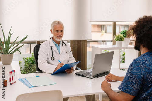 Mature man diagnosing anonymous black patient at appointment