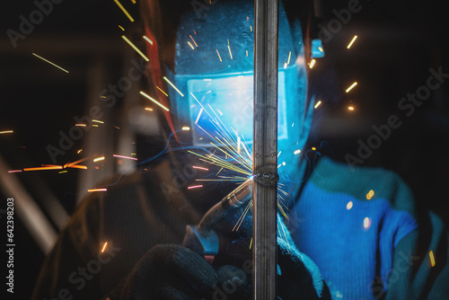 Welder is welding a metal pipes by semi automatic welding. photo