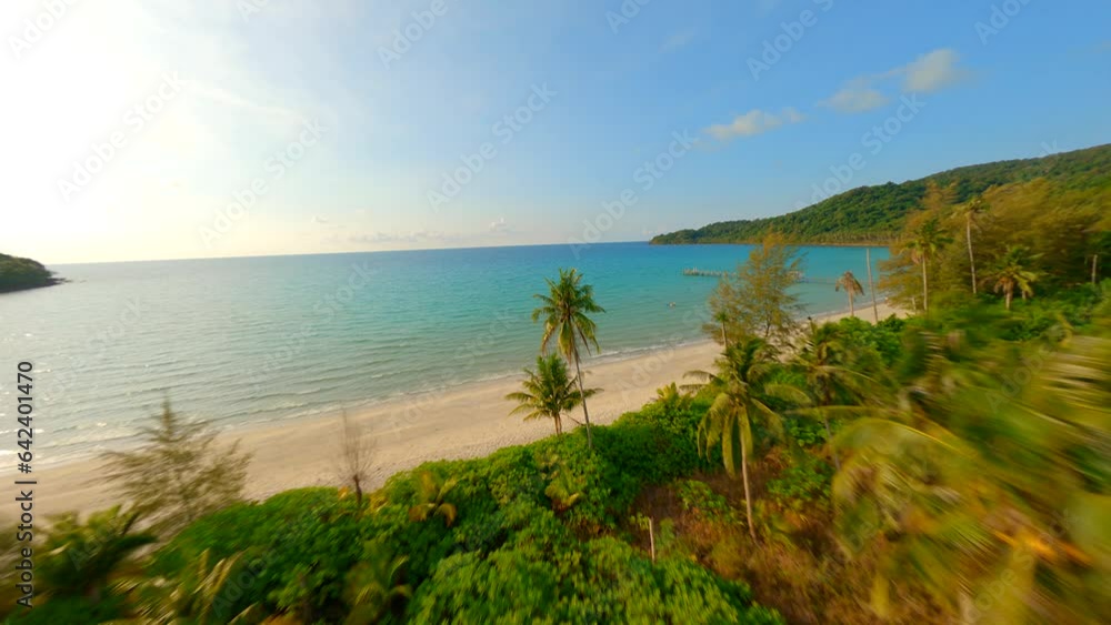 FPV drone flying close to towering coconut palm trees and over beautiful tropical sandy beach in Thailand. FPV drone flying close to towering coconut palm trees and over beautiful tropical sandy beach in Thailand.
