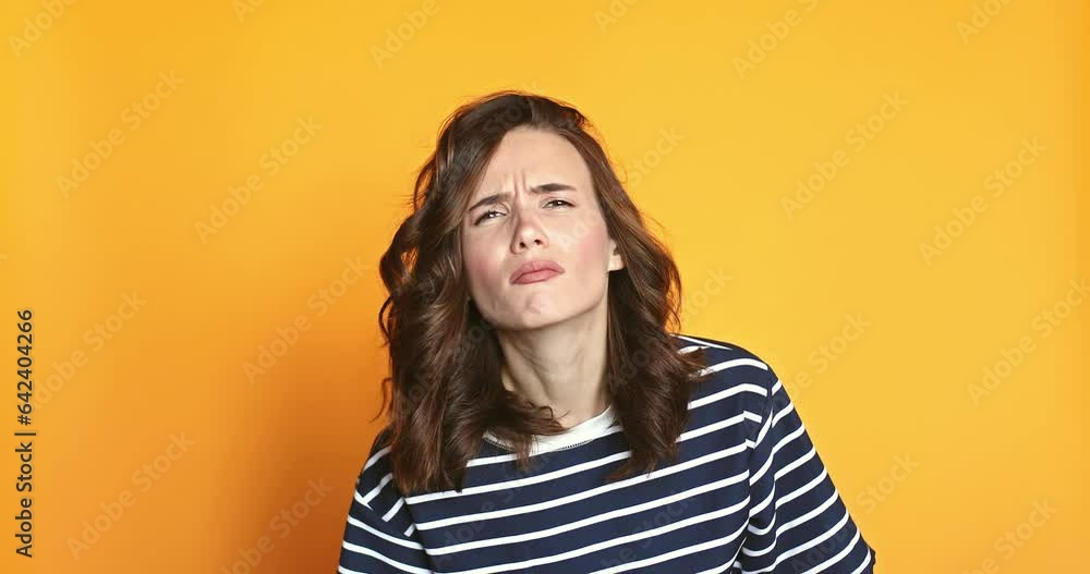 Doubtful woman looks with suspicion. Spy and curiosity concept. Curious, suspicious, looks with disbelief at camera isolated on yellow background. Girl not sure, shrugging shoulders, not know. Doubtful woman looks with suspicion. Spy and curiosity concept. Curious, suspicious, looks with disbelief at camera isolated on yellow background. Girl not sure, shrugging shoulders, not know.
