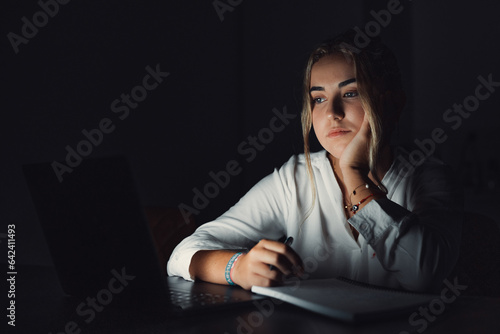 Exhausted upset young woman sit at office desk after end of workday alone massage temples trying to remember important information. Stressed tired female employee feel headache caused by work overtime photo