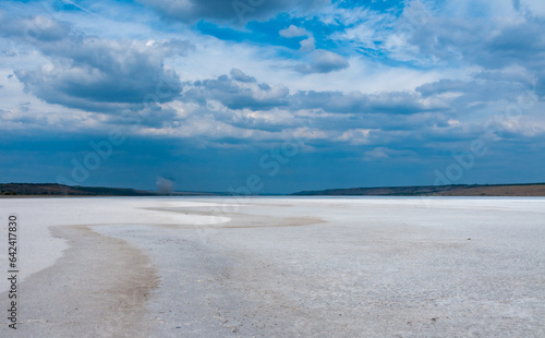 Rain cumulus clouds over the dry and self-sedimentary table salt covered muddy bottom