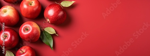 Red apples with leaves on red background photo