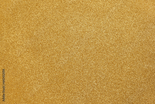 Gold background glitter. Gold sparkling. Glitter particles. Golden color. Noble paper. Gold Coated Paper. Rough surface. Valuable, expensive. Background for designs. Gold paper texture. Gold foil. photo