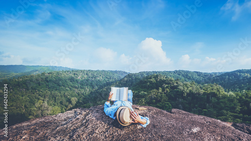 Asian man travel relax in the holiday. sleep relax read books on rocky cliffs. On the Moutain. In Thailand