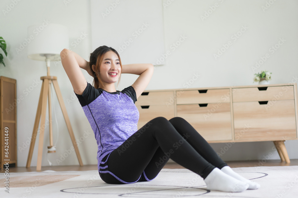 Young asian woman put hands behind head to doing exercise and workout for healthy lifestyle at home Young asian woman put hands behind head to doing exercise and workout for healthy lifestyle at home