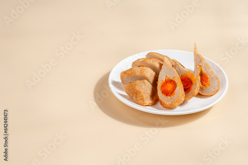 Pempek is a savoury Indonesian fishcake delicacy, made of fish and tapioca from Palembang. Pempek is served with sweet and sour sauce. photo