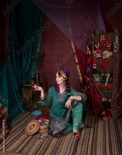 a woman in old Asian traditional outfits is buying in an old oriental shop. oriental bazaar, silk road