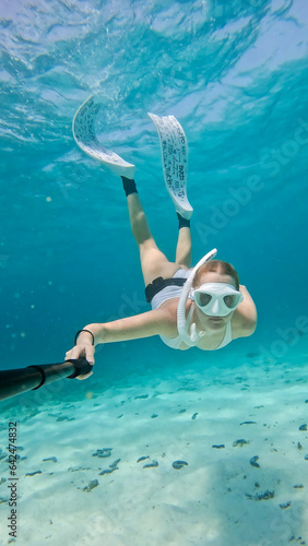 Female snorkeling swimming underwater in turqouise water. photo