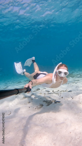 Female snorkeling swimming underwater in turqouise water. photo