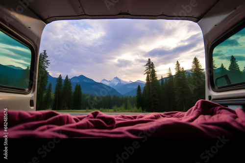Mountains and pine trees scene seen by camper inside camper van.