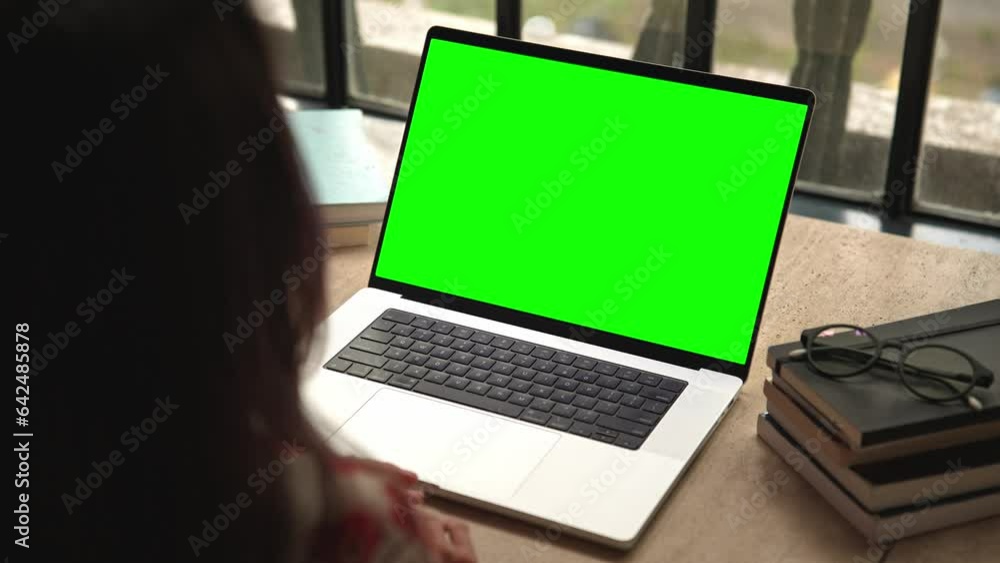 Woman Working on Laptop Computer and Looking at Green Screen Mockup for Chromakey and Talking on Video Call. Person Teleworking and Chatting in Discussion Close-Up. Watching Videocall or Reading Web Woman Working on Laptop Computer and Looking at Green Screen Mockup for Chromakey and Talking on Video Call. Person Teleworking and Chatting in Discussion Close-Up. Watching Videocall or Reading Web