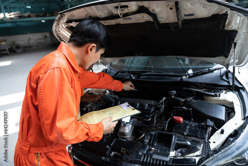 Automotive service mechanic inspect and diagnose car engine issue, repairing and fixing problem in garage workshop. Technician car care maintenance working on internal components of vehicle. Oxus photo