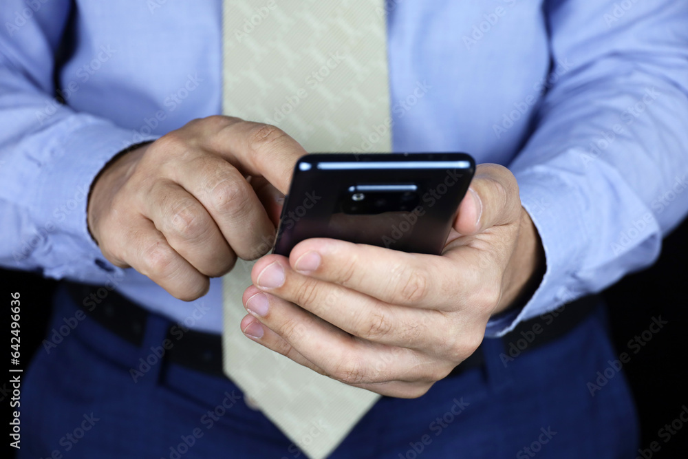 Man in office clothes holding smartphone in hands. Concept of online communication, sms Man in office clothes holding smartphone in hands. Concept of online communication, sms