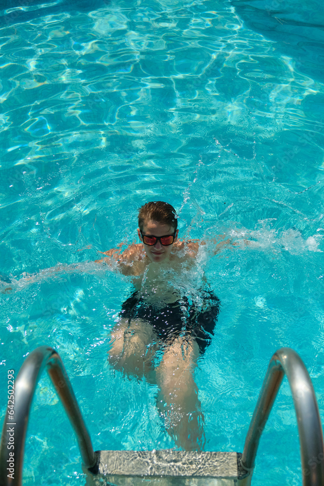 a boy swims in the pool