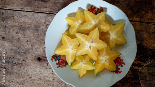 star fruit on plate with wooden background