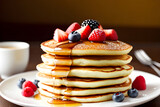 Stack of fluffy pancakes topped with a drizzle of maple syrup and fresh berries