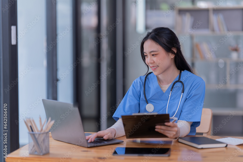 Portrait of Asian female doctor working on the desk and smiling Portrait of Asian female doctor working on the desk and smiling
