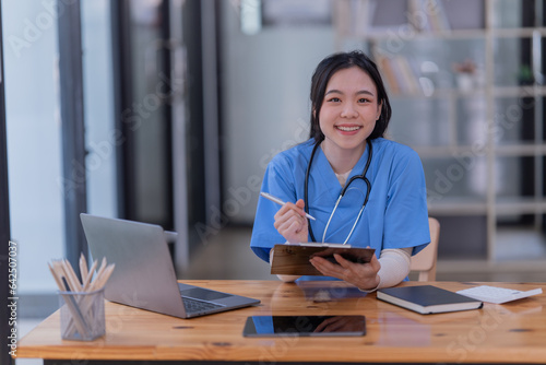 Portrait of Asian female doctor working on the desk and smiling