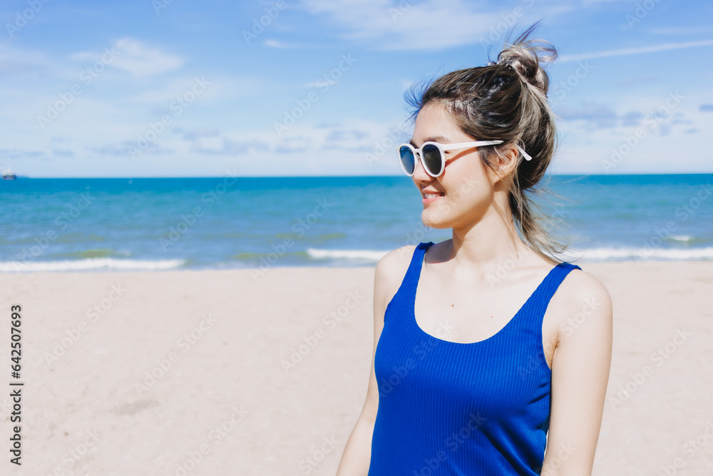 Happy asian woman on the sunny beach with sun glasses. Concept of sun protection Happy asian woman on the sunny beach with sun glasses. Concept of sun protection