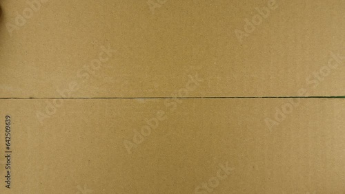Unpacking carton box with chromakey inside. Hand tears off adhesive tape from a cardboard box, view from the top