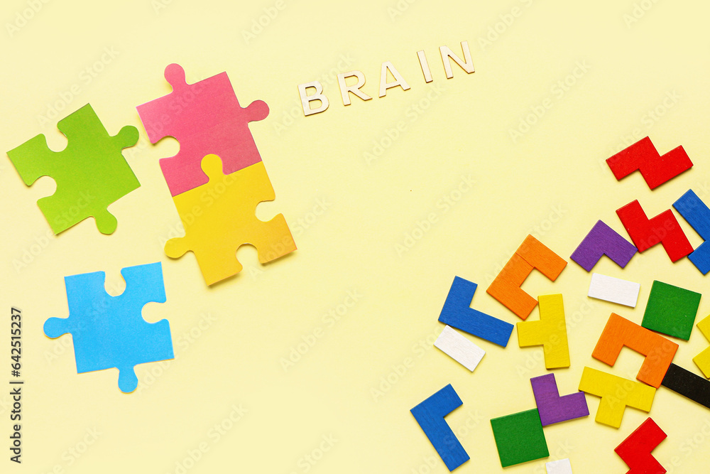 Word BRAIN with puzzle pieces and blocks on yellow background. Logic concept