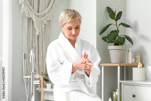 Mature woman applying hand ...