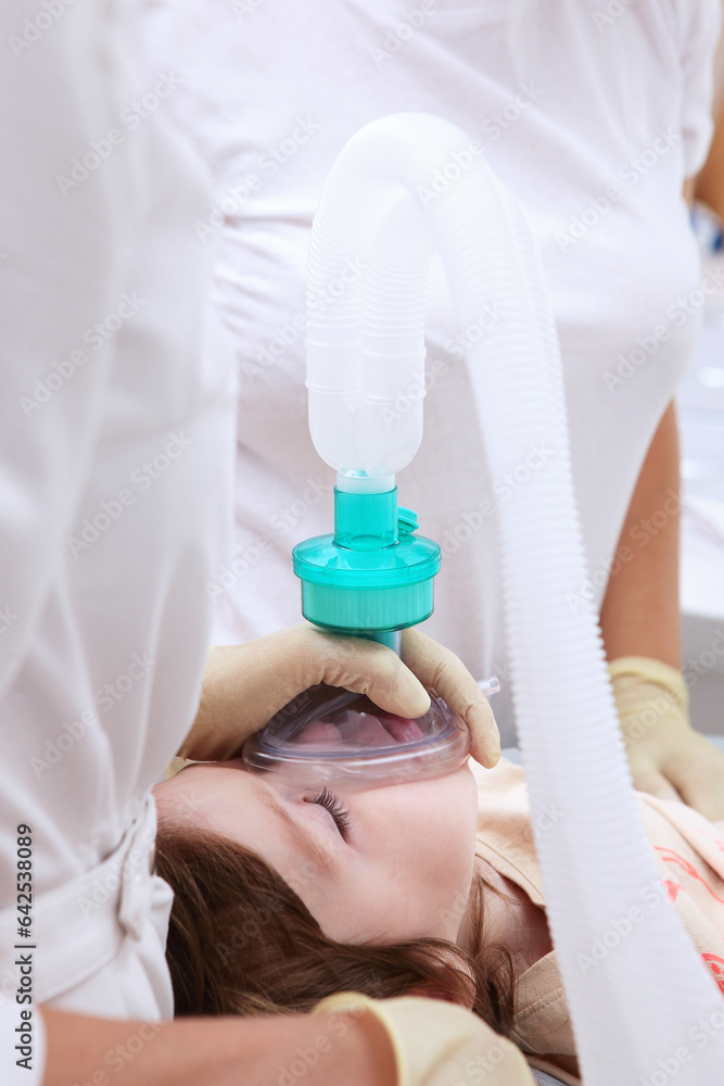 Naklejka premium Child is under anesthesia.Breathing tube in child's mouth. Open mouth. Modern dentistry.Vertical photo.