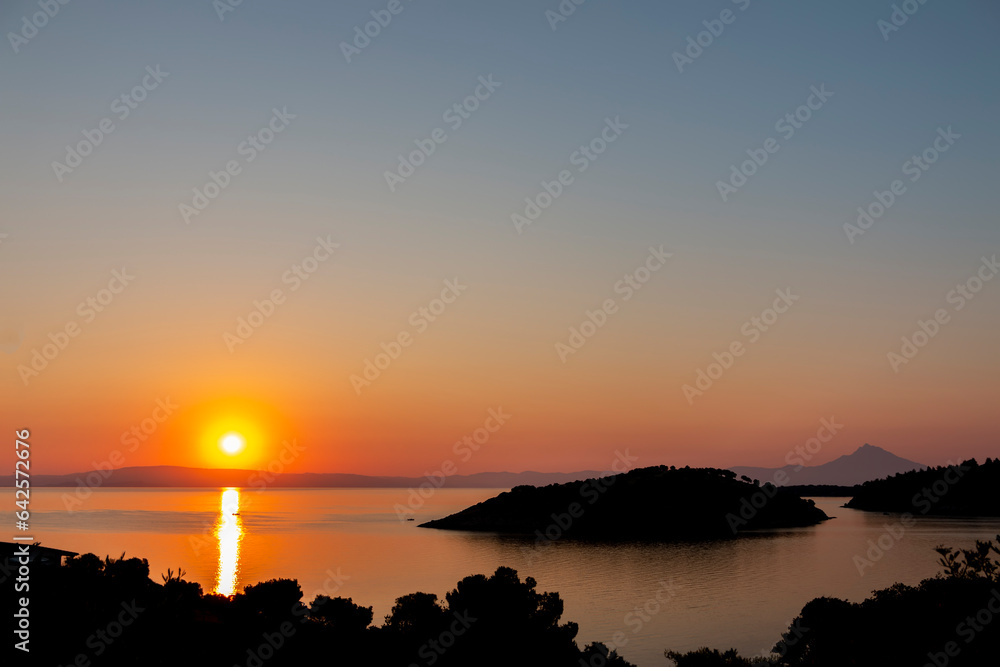 A beautiful sunrise over a serene sea, with colorful reflections shimmering on the water