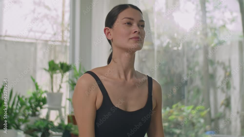 Young woman in sports bodysuit doing vinyasa yoga flow while exercising at home during daytime Young woman in sports bodysuit doing vinyasa yoga flow while exercising at home during daytime